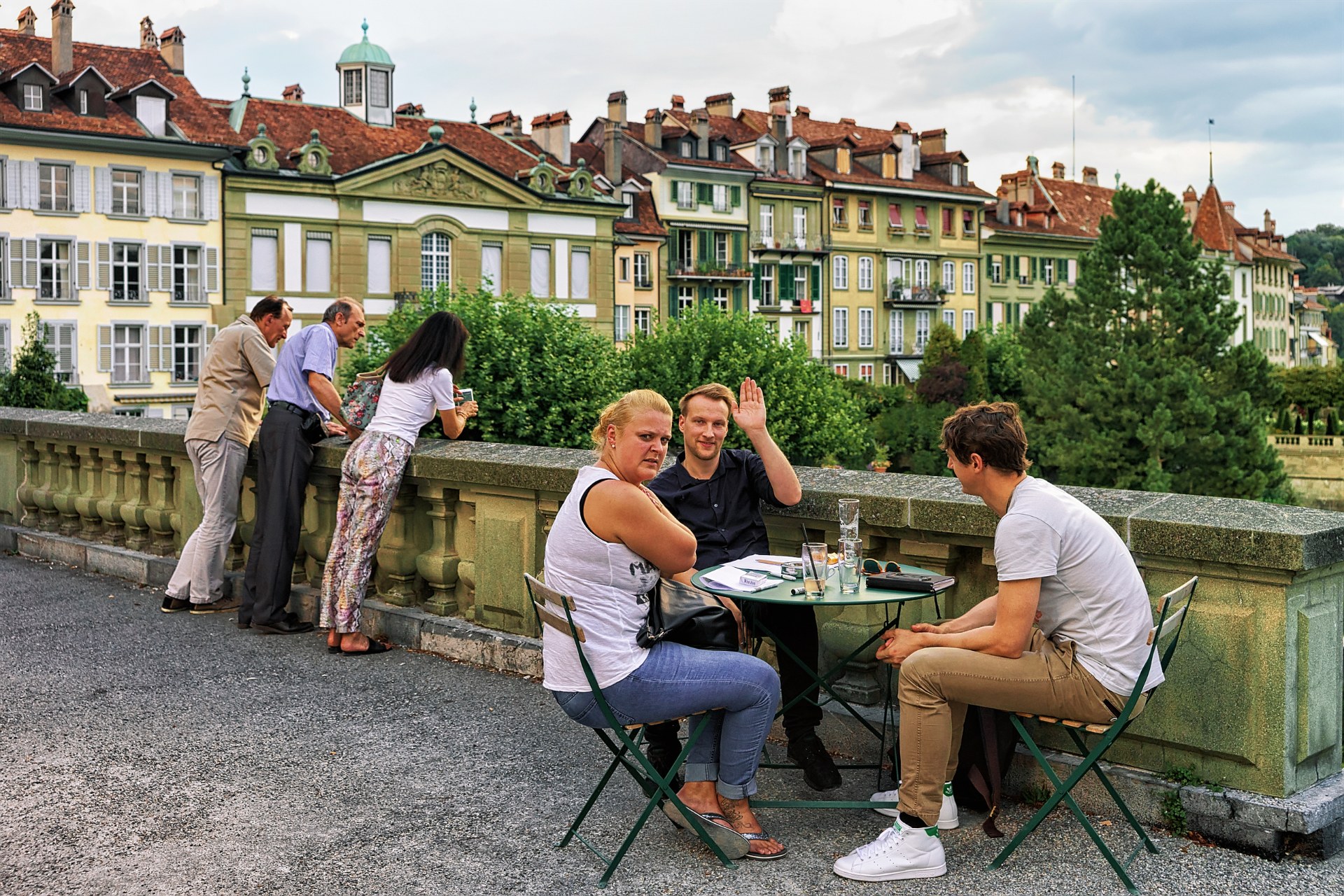 Znajomi przy stoliku kawiarni na tarasie Münsterplattform na starym mieście w Bernie