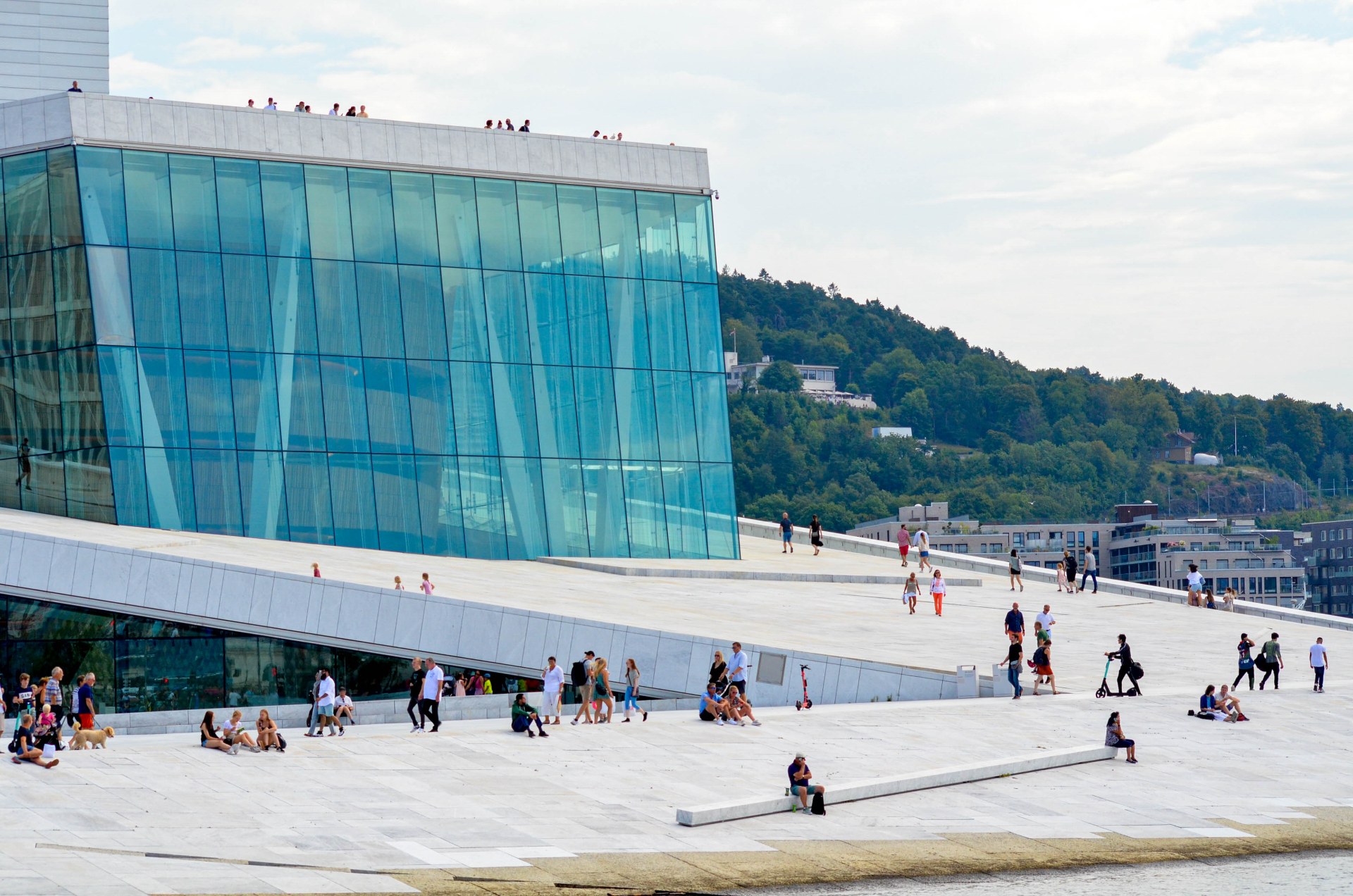 Ludzie spacerujący i odpoczywający na dachu gmachu Opery w Oslo